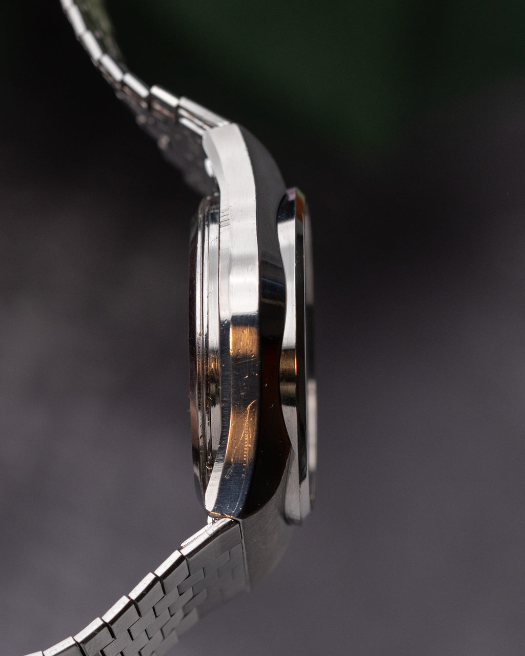 Close-up of a silver watch with a dark background