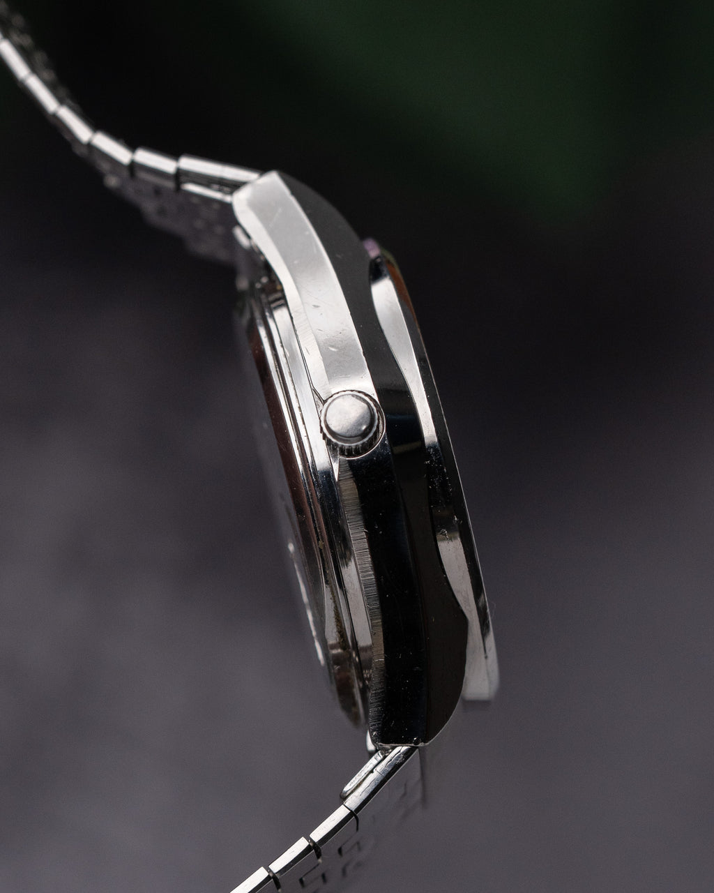 Close-up of a silver watch with a dark background