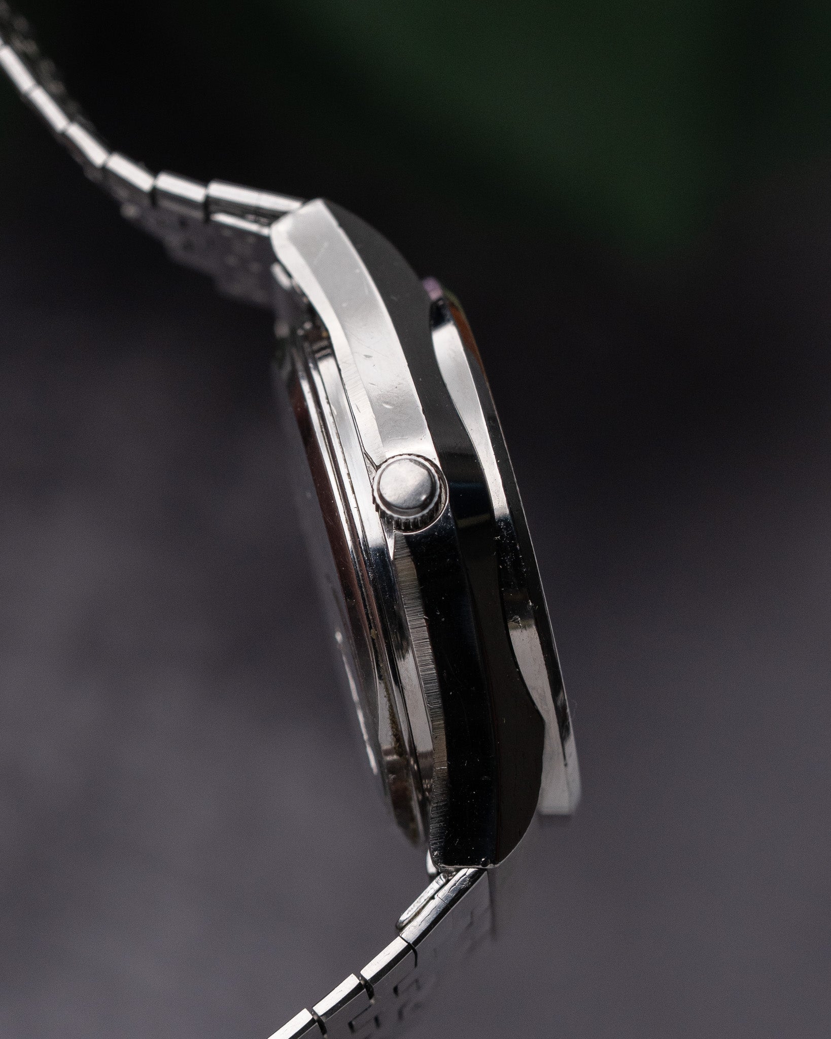 Close-up of a silver watch with a dark background