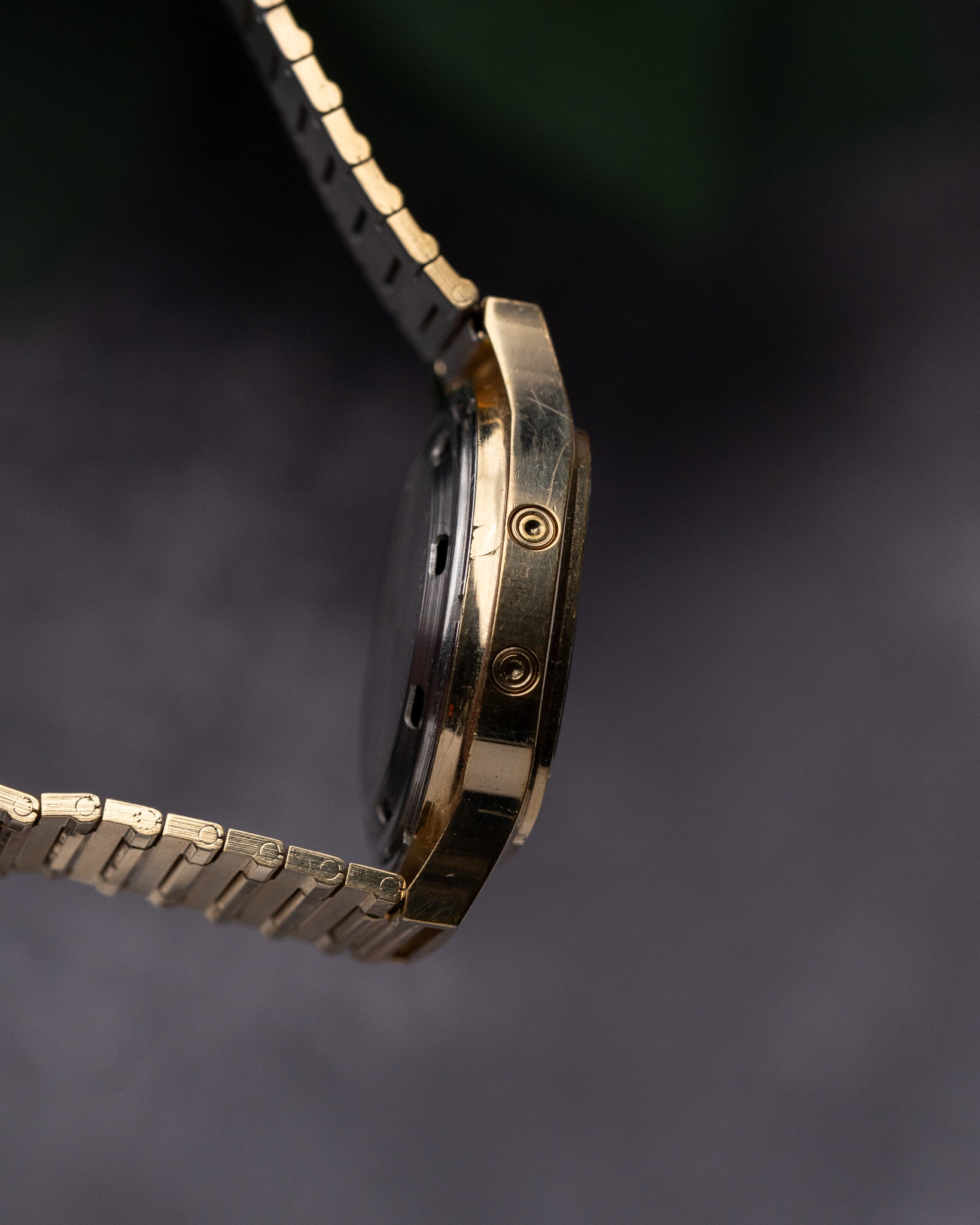 Gold watch strap on a dark background