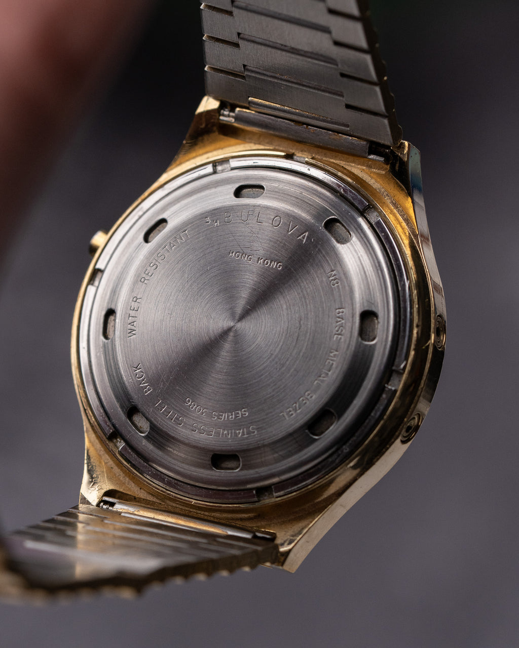 Close-up of a watch case with brand engraving on a dark background